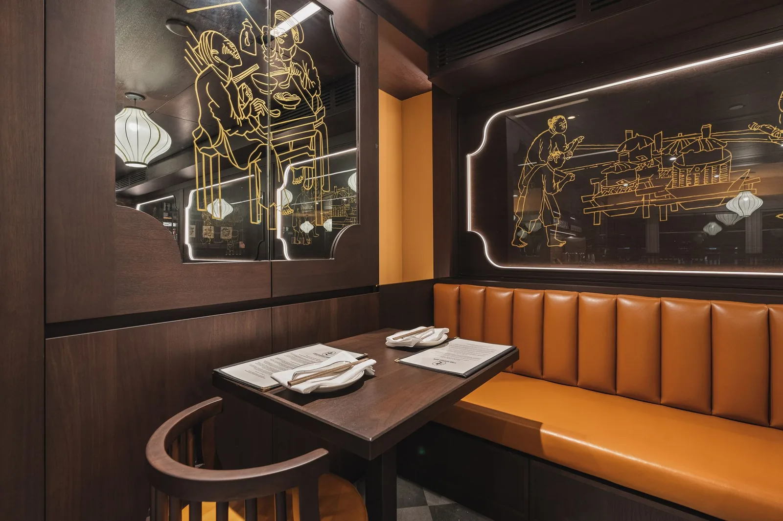 Corner booth below an etched glass panel with a gold line drawing, Linh Noodle Bar by Costar Construction, Vancouver