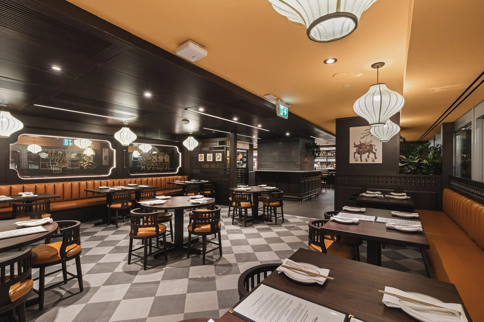 Booth and tables under large lanterns, with etched panels on the wall, Linh Noodle Bar by Costar Construction, Vancouver