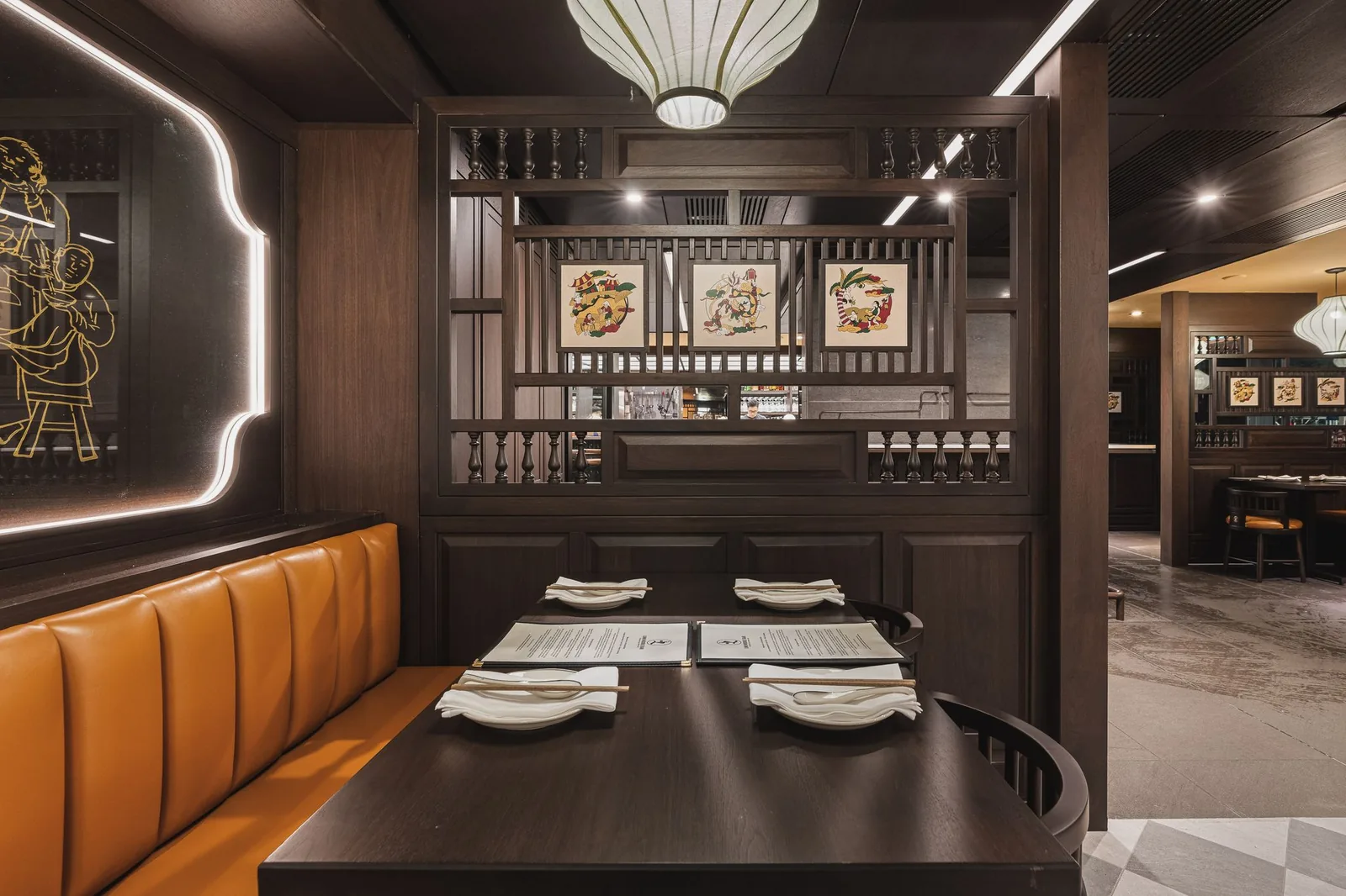 Booth beside a wood screen with three framed prints, Linh Noodle Bar by Costar Construction, Vancouver