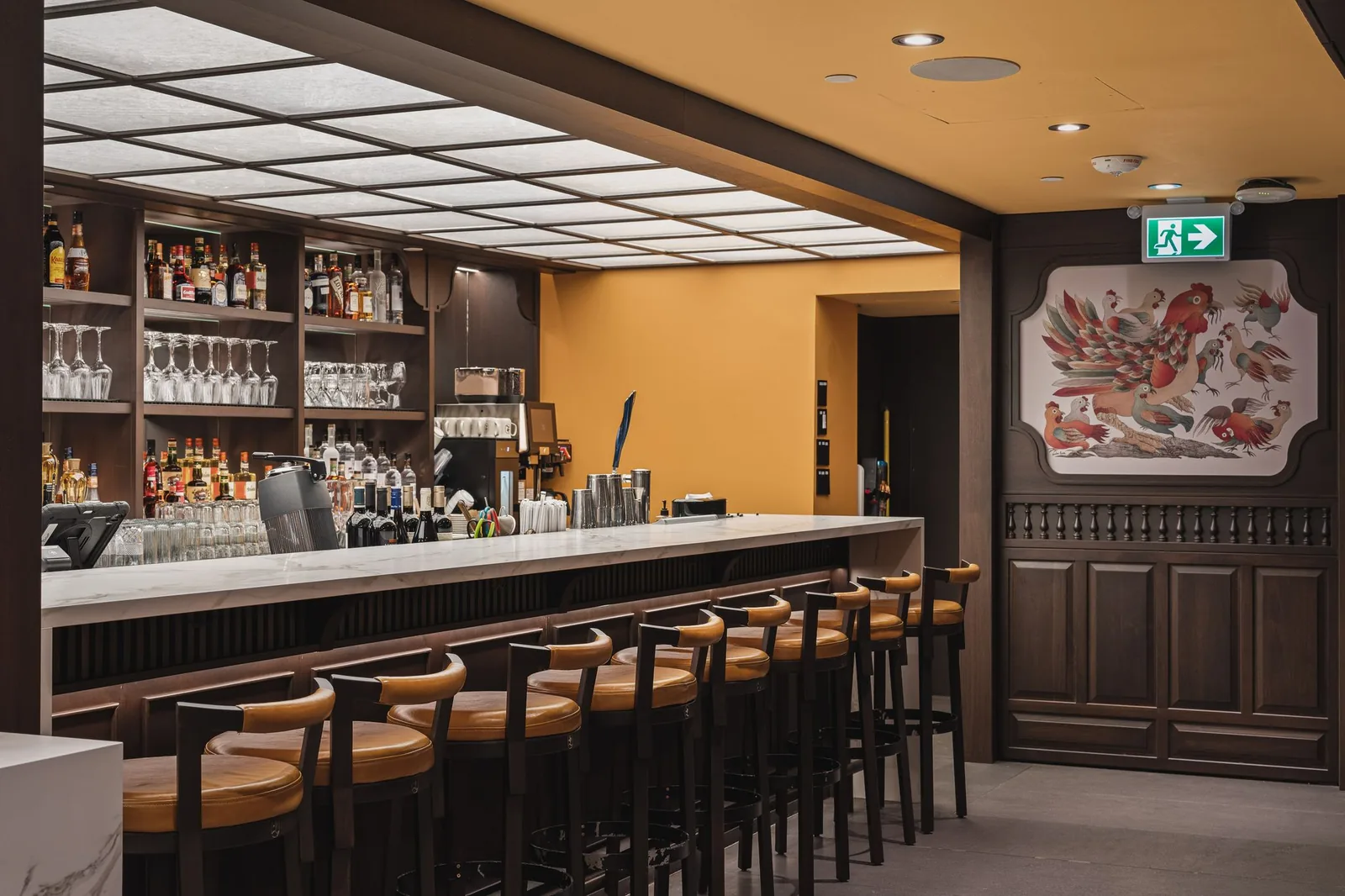 Bar with leather stools, bottle shelves and a lit panel ceiling, Linh Noodle Bar by Costar Construction, Vancouver