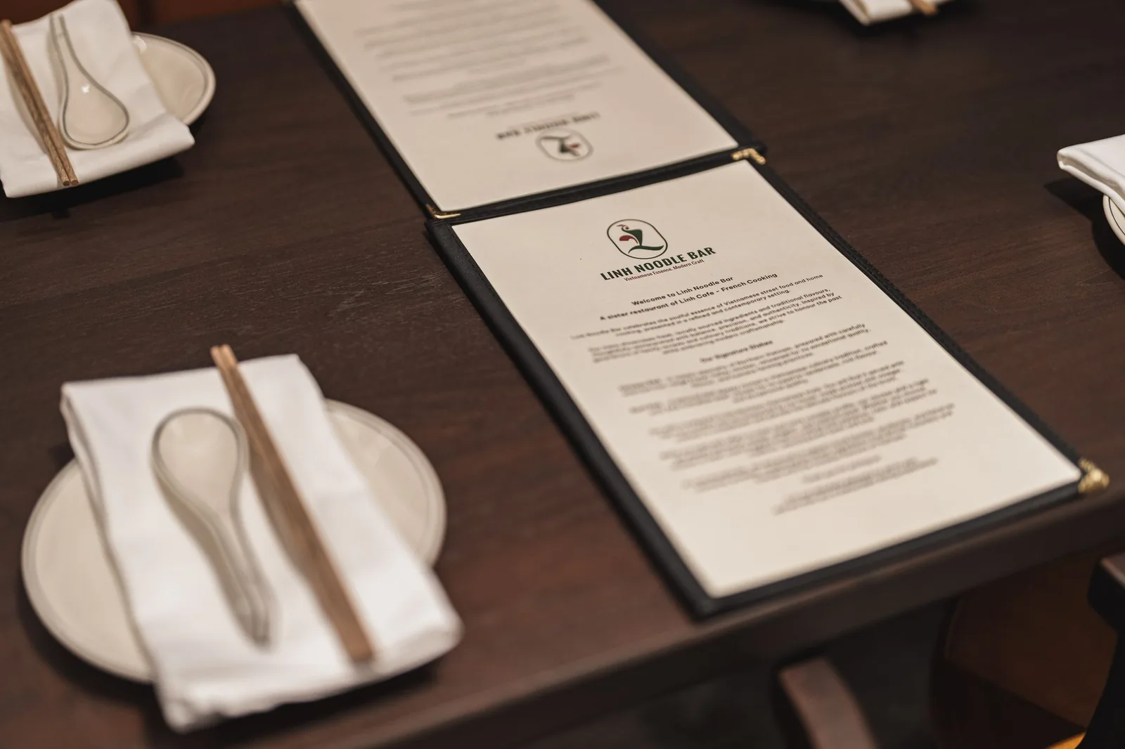 Table setting with a soup spoon, chopsticks and a Linh Noodle Bar menu, Linh Noodle Bar by Costar Construction, Vancouver