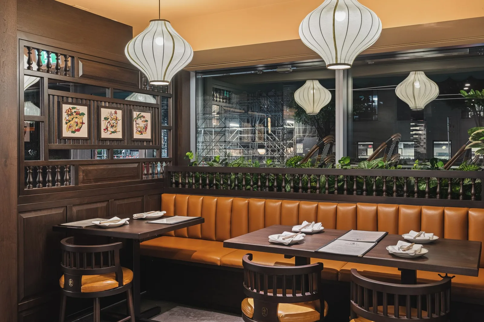 Window booth under lanterns, with framed prints on a wood screen, Linh Noodle Bar by Costar Construction, Vancouver