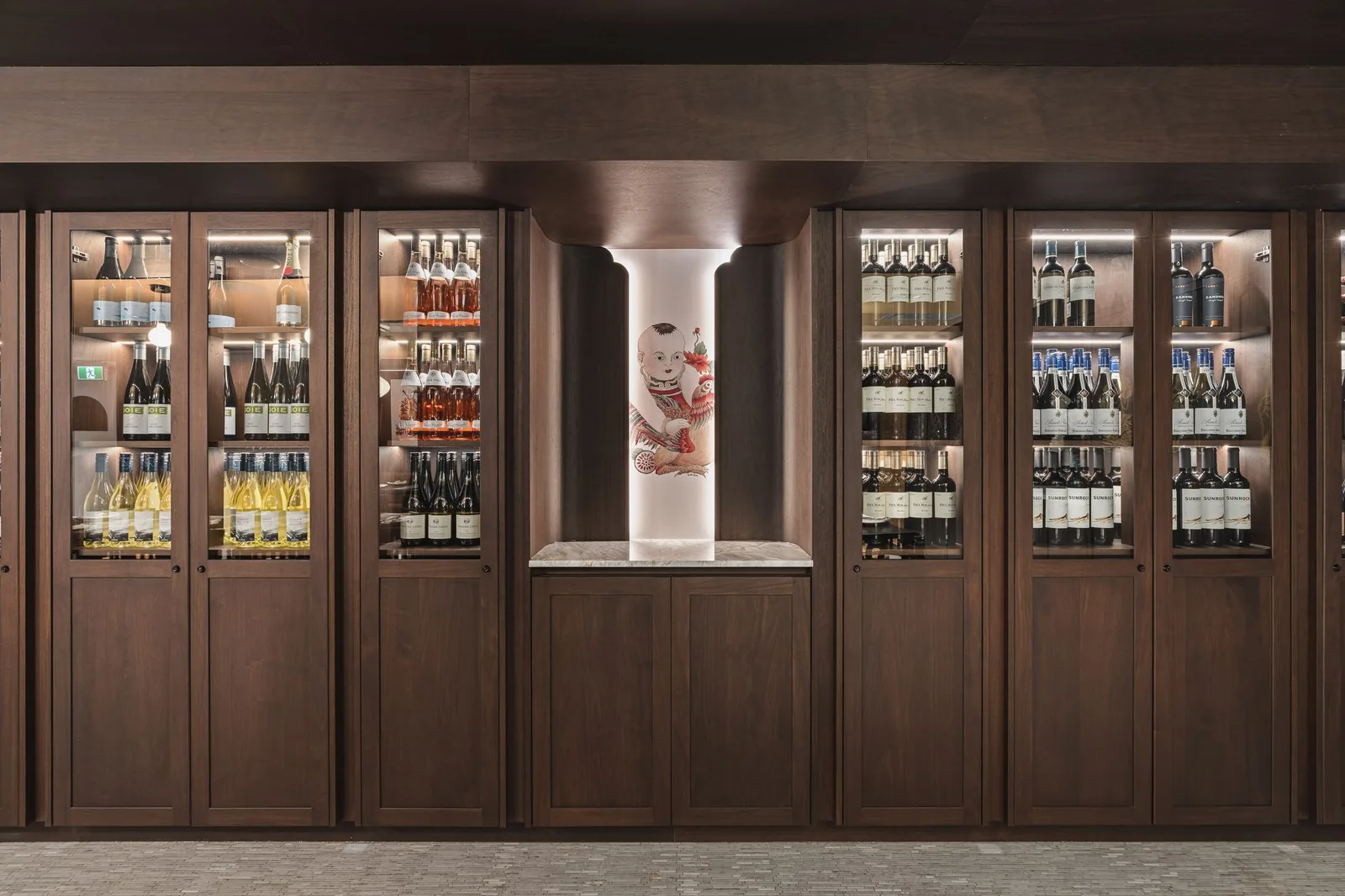 Wine cabinets with glass doors on each side of a lit painted column, Linh Noodle Bar by Costar Construction, Vancouver