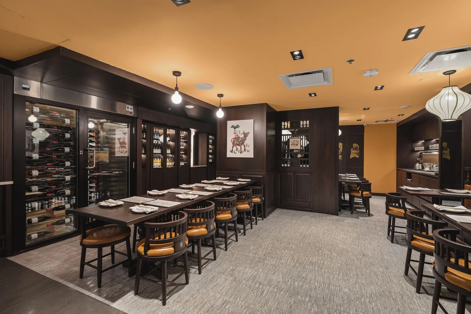 Long table between a glass wine room and dark wood panelling, Linh Noodle Bar by Costar Construction, Vancouver