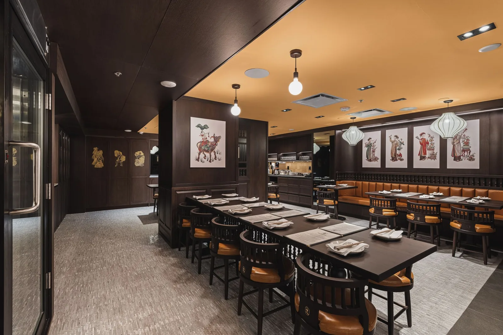Long table and booths below four framed prints, Linh Noodle Bar by Costar Construction, Vancouver
