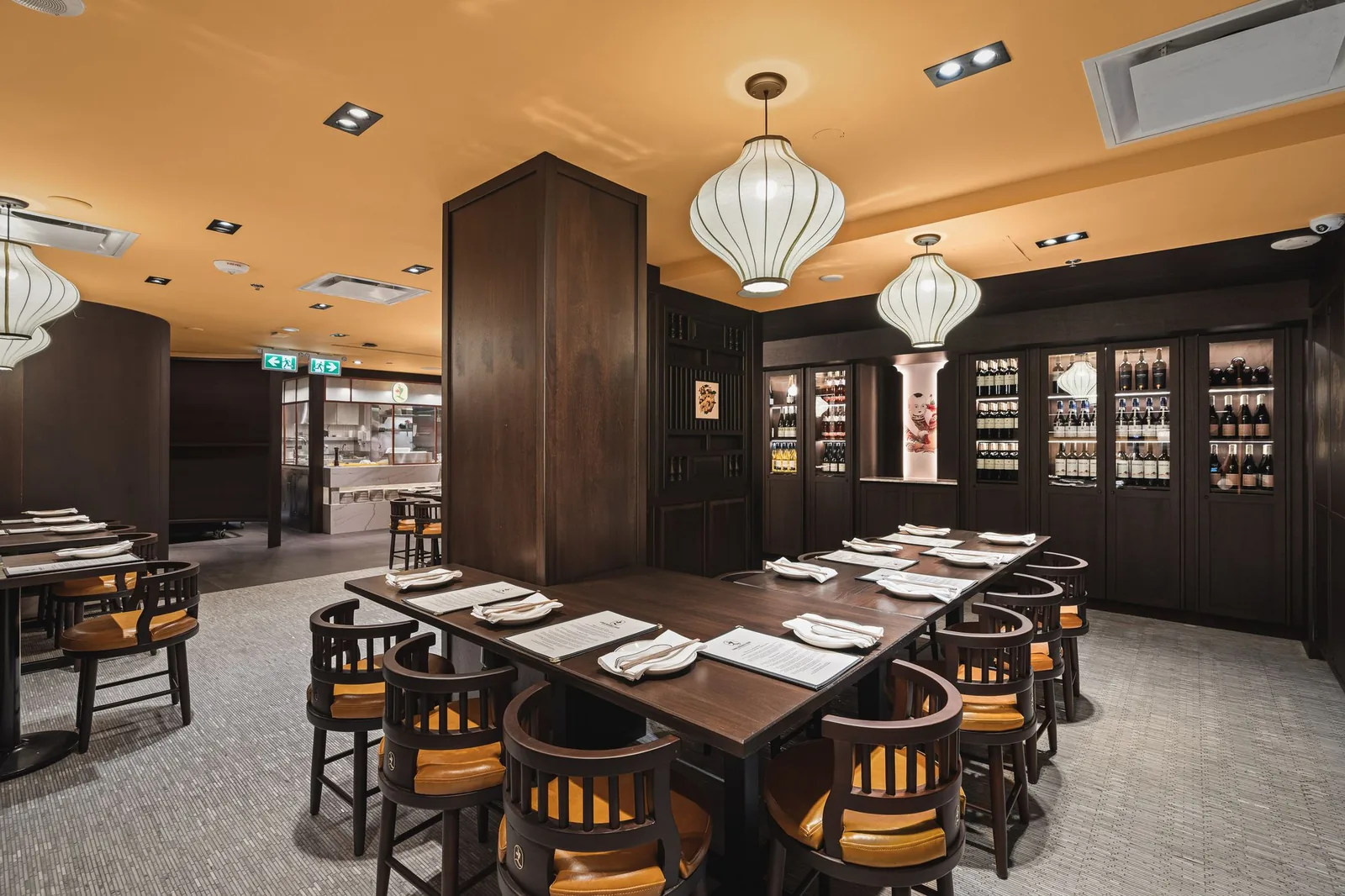 Long table by a column, with wine cabinets along the back wall, Linh Noodle Bar by Costar Construction, Vancouver