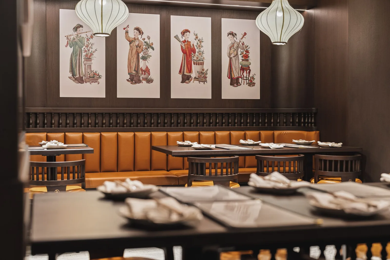 Booth below four framed prints, seen past a set table, Linh Noodle Bar by Costar Construction, Vancouver