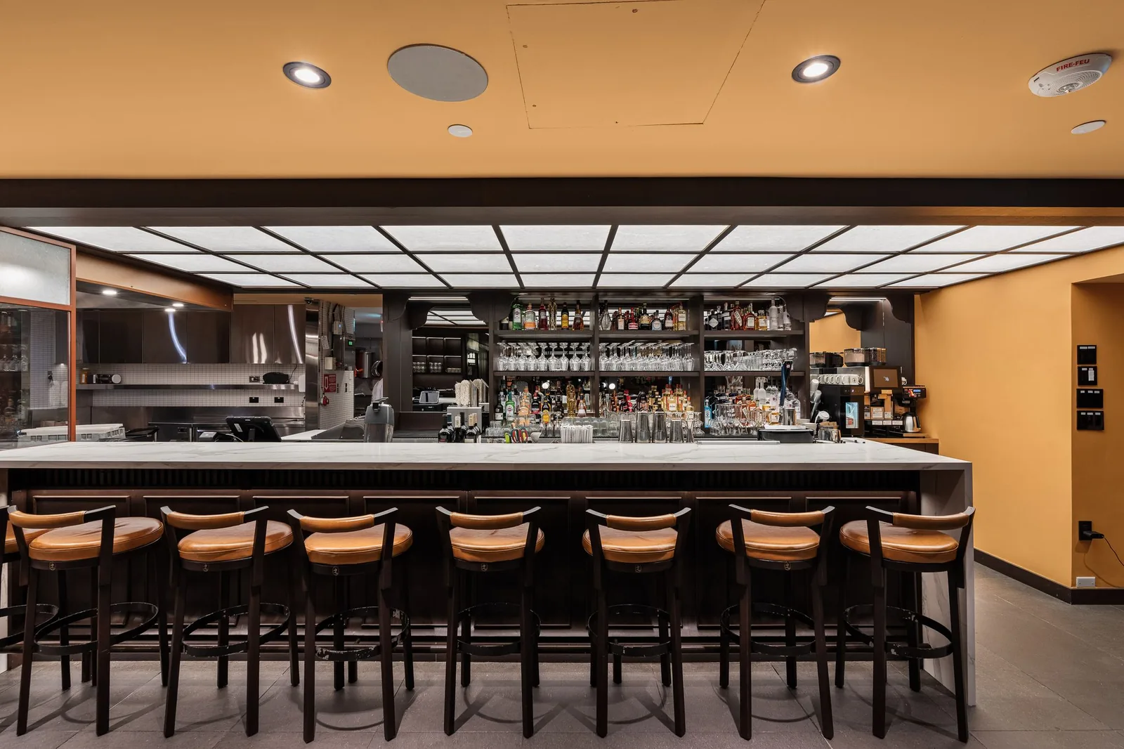Front view of the bar and its row of leather stools, Linh Noodle Bar by Costar Construction, Vancouver