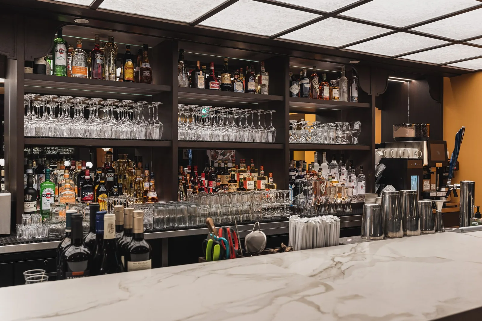 Bottle and glass shelves behind the white stone bar top, Linh Noodle Bar by Costar Construction, Vancouver