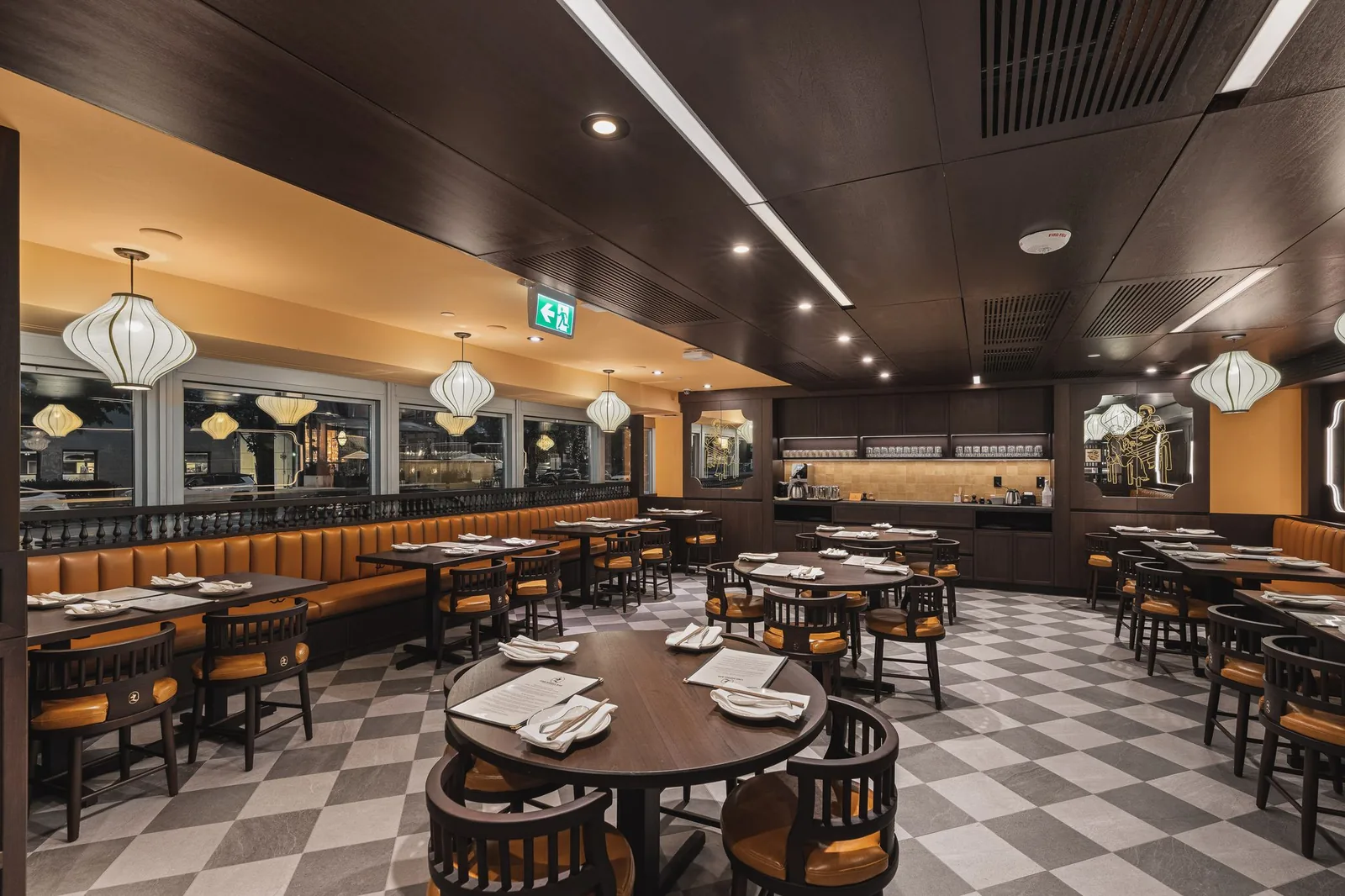 Dining room with booths along the windows and round tables under lanterns, Linh Noodle Bar by Costar Construction, Vancouver