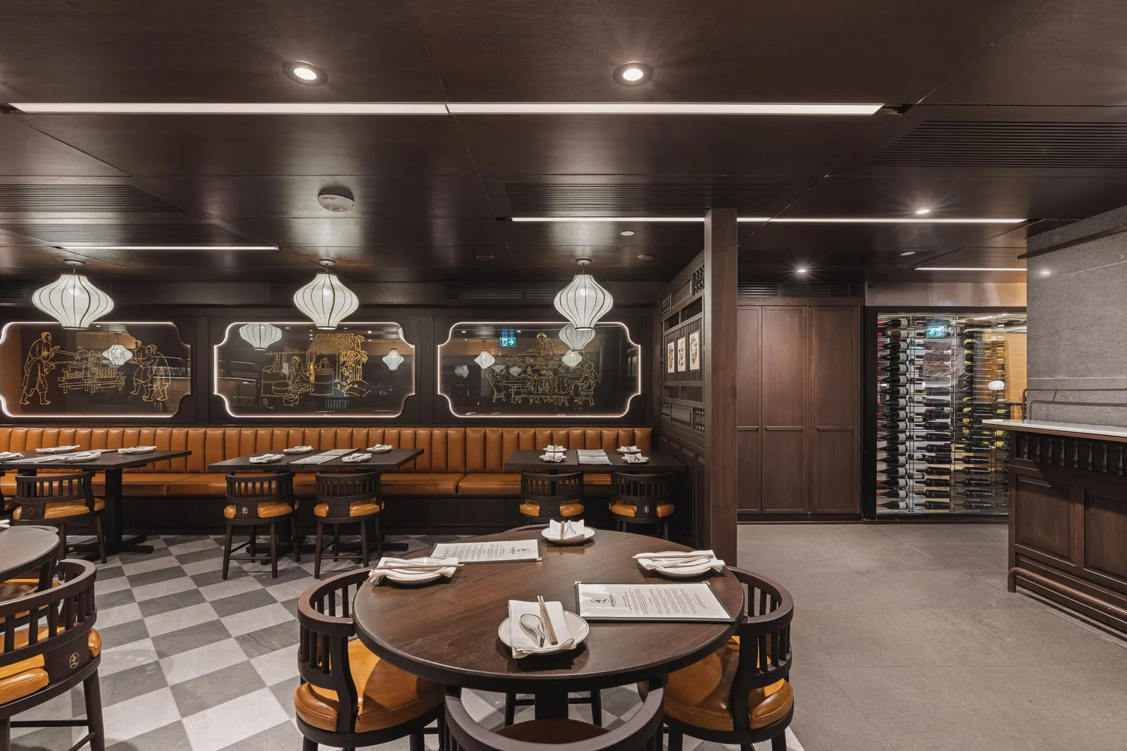 Round table set for service, with booths and a glass wine room behind, Linh Noodle Bar by Costar Construction, Vancouver