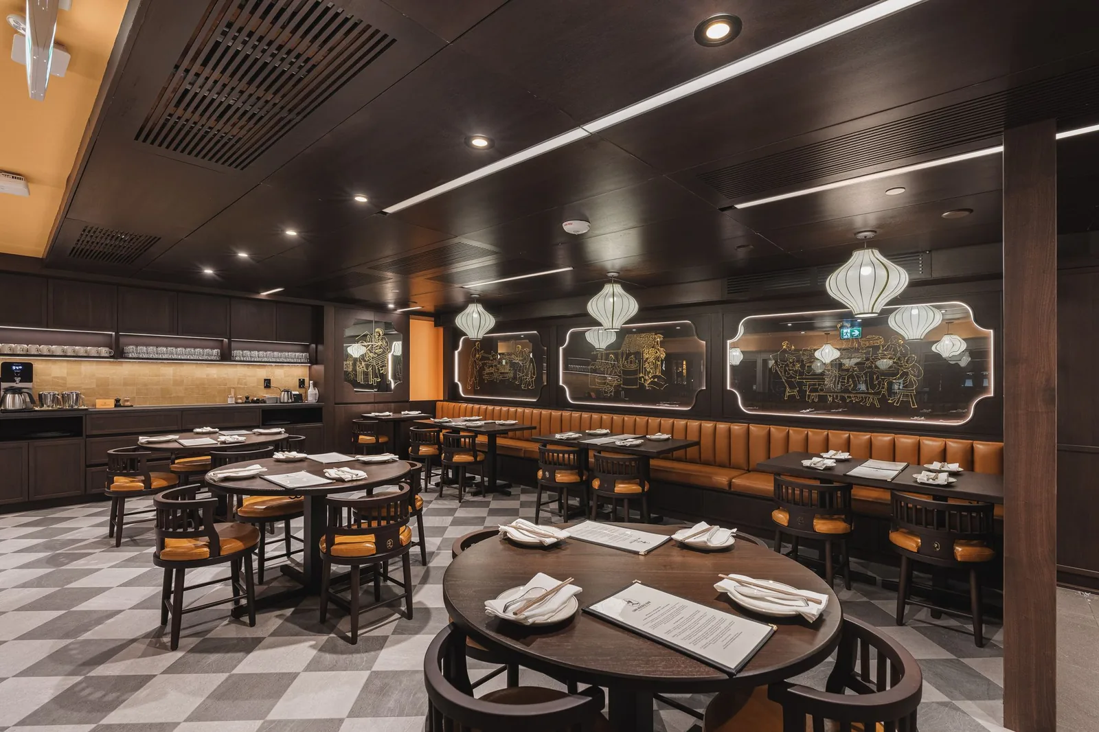 Round table and booths below backlit etched glass panels, Linh Noodle Bar by Costar Construction, Vancouver