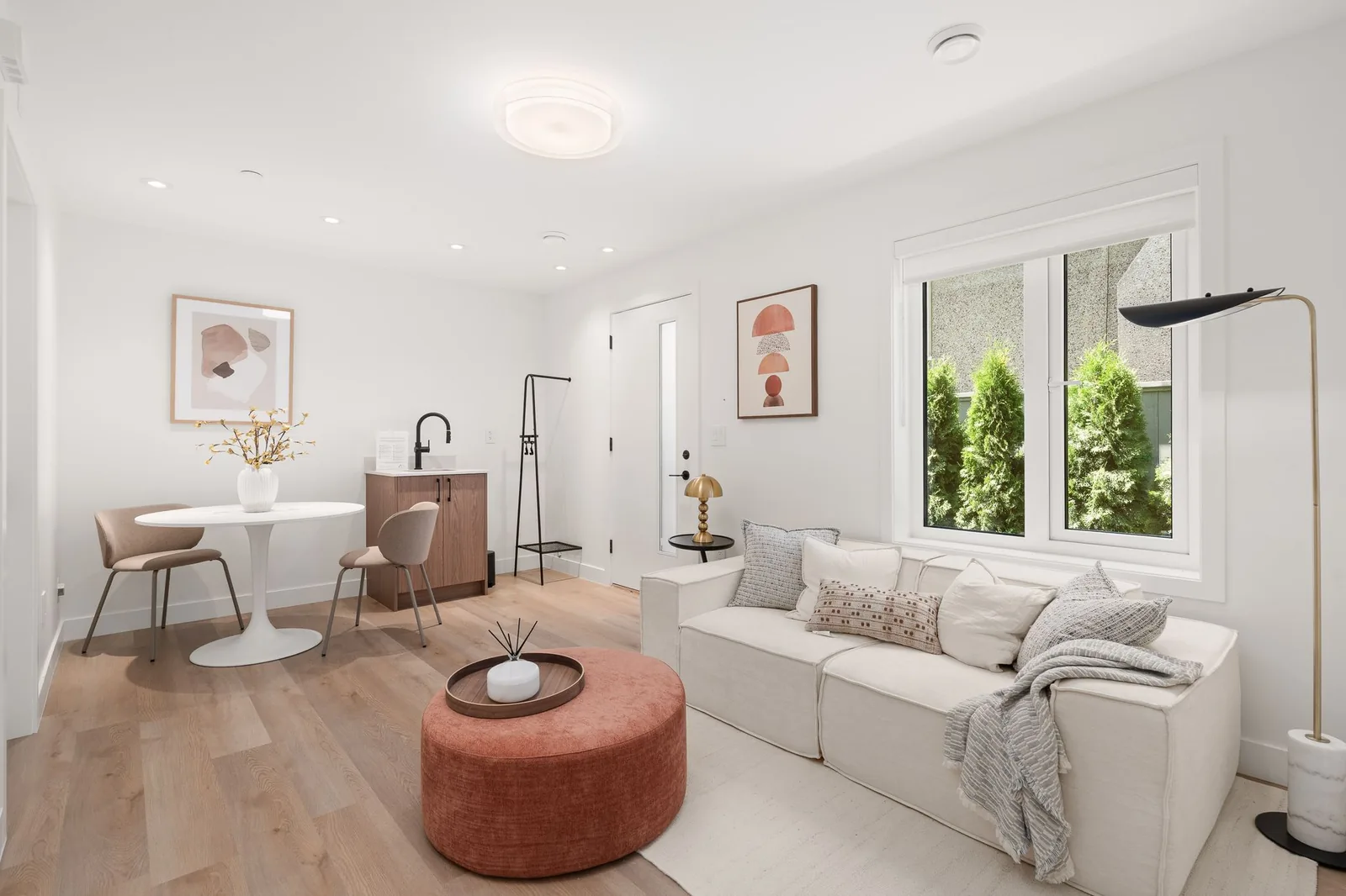 Living area of a ground-floor suite at Quintet, with its own entrance door, a wet bar and a window to a planted side yard